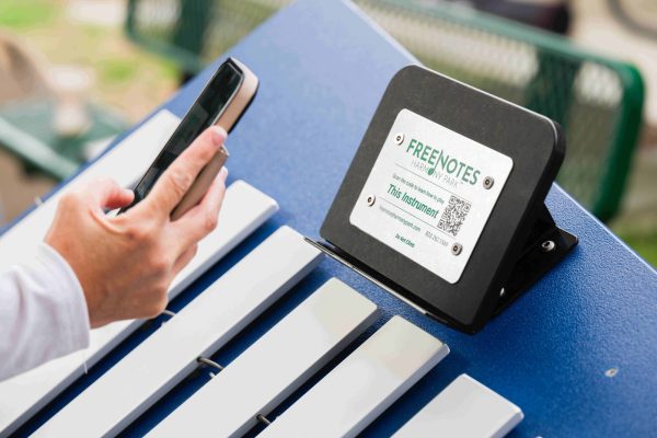 Person scanning QR Code on the device holder with their phone